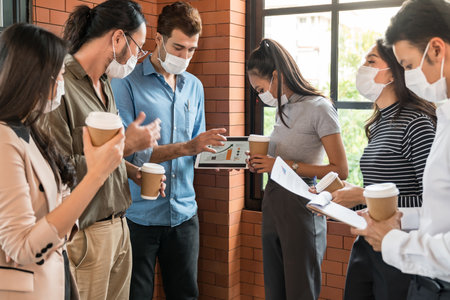 Group of business worker team meeting and brainstorm for startup new business. They wear protective face mask in new normal office preventing coronavirus COVID-19 spreading.の写真素材