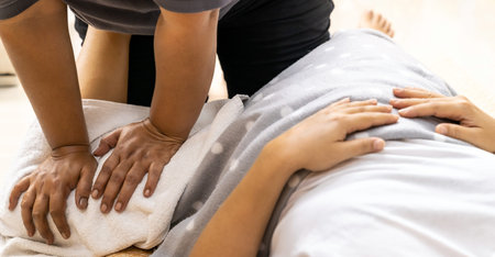 Panoramic Asian woman do massage at home with face mask as new normal for social distance due to...