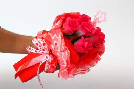 Woman hands holding red plastic roses on a white background.の写真素材