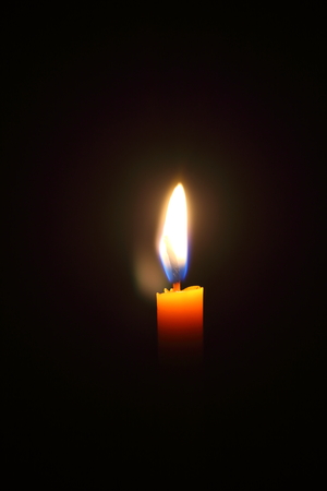 Lighting candles on a black background.の写真素材