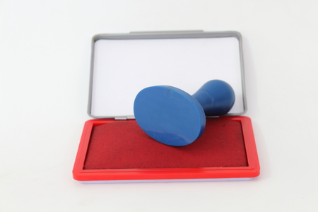 Red rubber stamp and ink on a white background.の写真素材