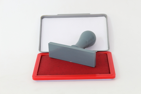 Red rubber stamp and ink on a white background.の写真素材