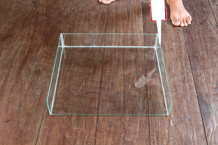 Men are firing silicone to clear the glass to a rectangular shape for feeding fish.の写真素材