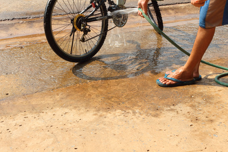Men are washing their bicycles in the daytime.の写真素材