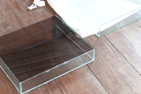 Square glass bowl for fish bowls placed on a wooden background.の写真素材