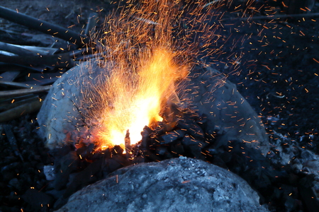 Sparkling orange light from a charcoal stove to make a knife.の写真素材