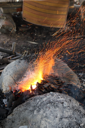 Sparkling orange light from a charcoal stove to make a knife.の写真素材