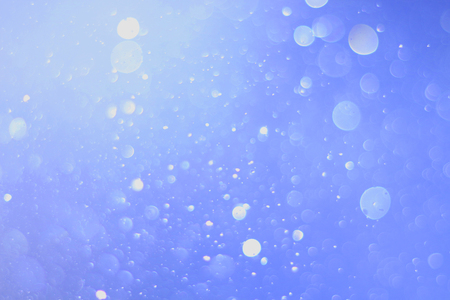 A beautiful and blurry bokeh on a blue background.の写真素材