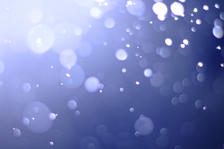 A beautiful and blurry bokeh on a blue background.の写真素材