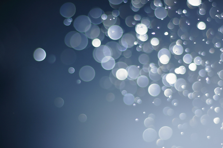 A beautiful and blurry bokeh on a blue background.の写真素材