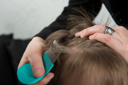Mother checking childs head for lice with a comb