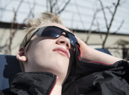 Male teenager enjoying the first warming sunbeams at springtimeの写真素材