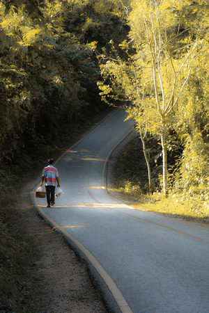 a man walk alone in a long roadの写真素材