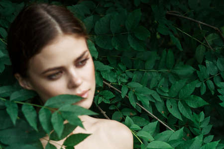 portrait of a woman skin care bare shoulders green leaves nature modelの写真素材