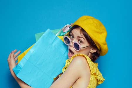 glamorous woman in a yellow hat Shopaholic fashion style blue backgroundの写真素材