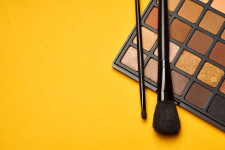 cosmetics mascara brushes decoration accessories yellow backgroundの写真素材