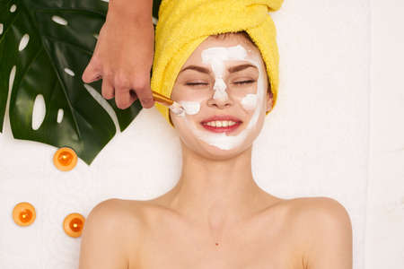 cheerful woman with a towel on my head skin care light backgroundの写真素材