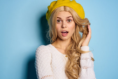 woman in yellow hat posing glamor blue background