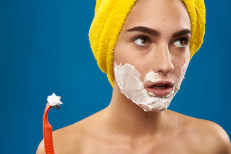 pretty woman razor in hand skin care hygiene blue backgroundの写真素材