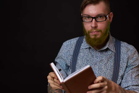 man in glasses with a notebook in his hands training professional officeの写真素材