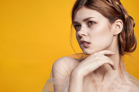 pretty woman gesture hands cosmetics fashion hairstyle posing yellow background