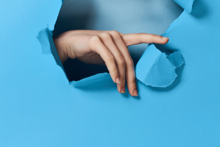 female hand blue background posing glamor modelの写真素材
