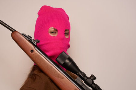woman gangster with a gun in hand Lifestyle beige background