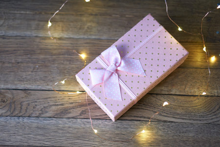 pink gift box garland decoration wooden background holiday