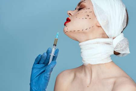 a person posing in blue gloves red lips surgery facial rejuvenation close-upの写真素材