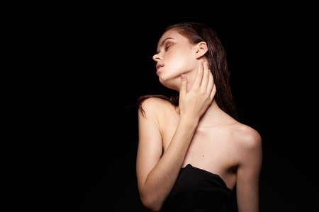 portrait of a woman bare shoulders clean skin wet hair dark backgroundの写真素材