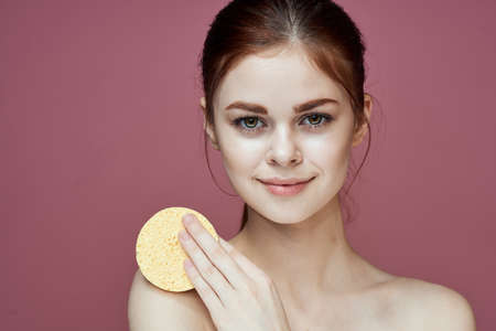 woman with bare shoulders sponge in hands clean skin hygieneの写真素材