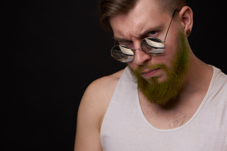 handsome man with tattoos on his arms fashion sunglasses dark background