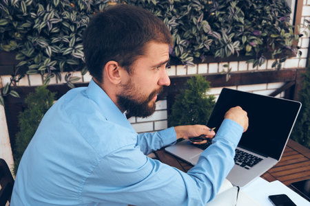 business man outdoors with laptop in cafe emotions