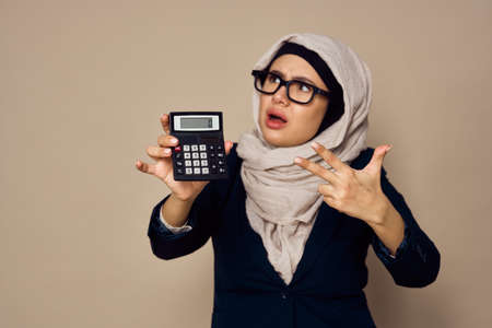 muslim woman with calculator in hands work office businessの写真素材