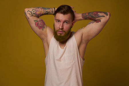 macho man in white t-shirt tattoos on his arms posing isolated background