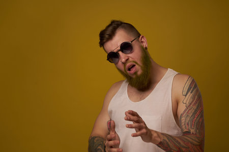 man in a white t-shirt tattoos on his arms fashion glasses modern style