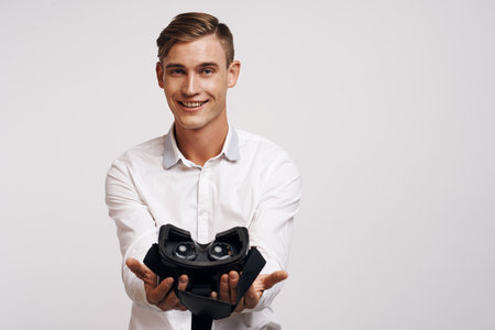 Cheerful man virtual reality glasses high-tech simulator light backgroundの写真素材