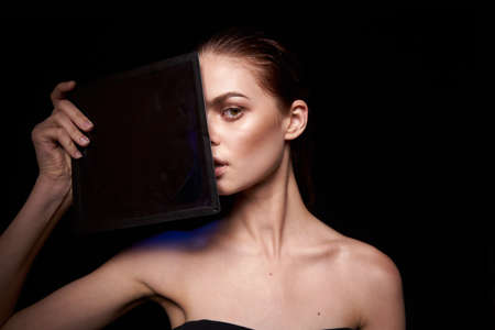 beautiful woman emotions gesture hands bare shoulders dark backgroundの写真素材