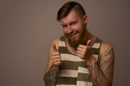 fashionable man with tattoos on his arms stylish hairstyle self-confidence studioの写真素材