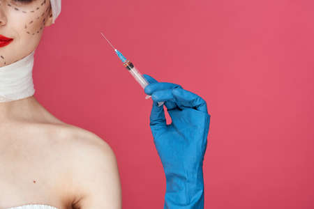 woman posing in blue gloves red lips surgery facial rejuvenation studio lifestyleの写真素材