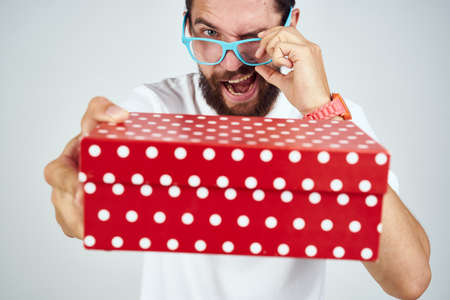 man with gift box wearing glasses holiday fun light backgroundの写真素材