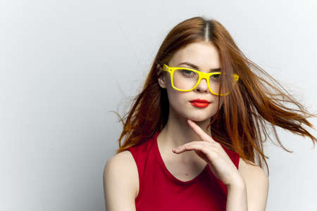pretty woman yellow glasses and red lips fashion light backgroundの写真素材