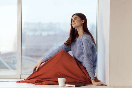 woman sitting on windowsill rest plaid morning lifestyleの写真素材