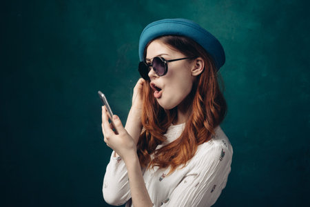 fashionable woman in blue hat with phone in hands communication technology