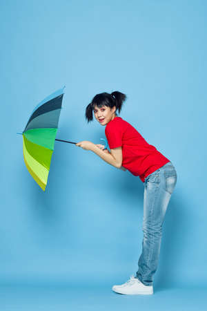 cheerful woman in red t-shirt rainbow color umbrella fashionの写真素材