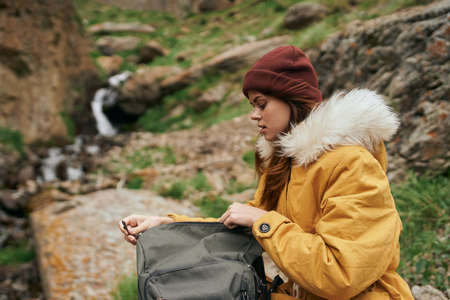 woman in yellow jacket hiking in the mountains travel adventureの写真素材