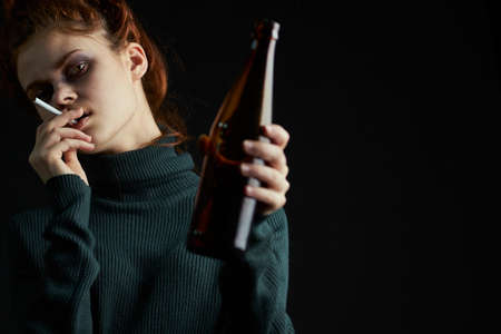 woman with cigarette bottle of alcohol bruises under eyes problems depressionの写真素材