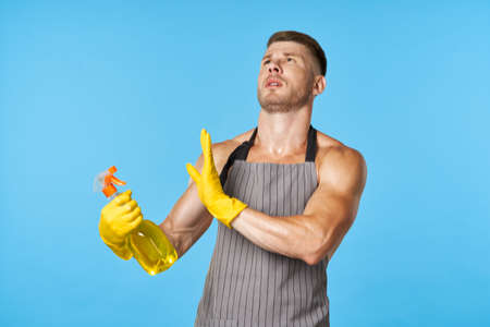 a man with a pumped-up body in aprons detergent cleaningの写真素材