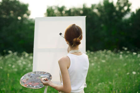 woman artist outdoors easel drawing creative landscapeの写真素材