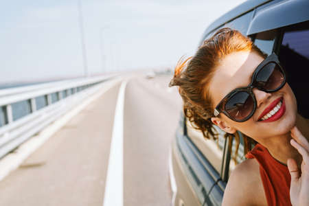 woman looking out of car window wearing sunglasses travel lifestyleの写真素材